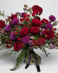 Crimson Lust Fresh Flower Bouquet features deep reds and rich purples, each flower meticulously selected to create a luxurious tapestry ideal for International Women's Day and Mother's Day, Valentine's Day and other important moments. This luxury floral arrangement is dominated by the romantic allure of velvety red roses, their full blooms symbolising love and respect. Dark red dahlias add a lush, textural contrast with their intricate petals.