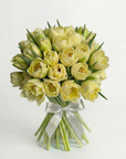 Luxury hand-tied bouquet of pale yellow and cream tulips arranged in elegant dome shape, featuring green stems bound with silver Amarante ribbon against white background - Amarante London