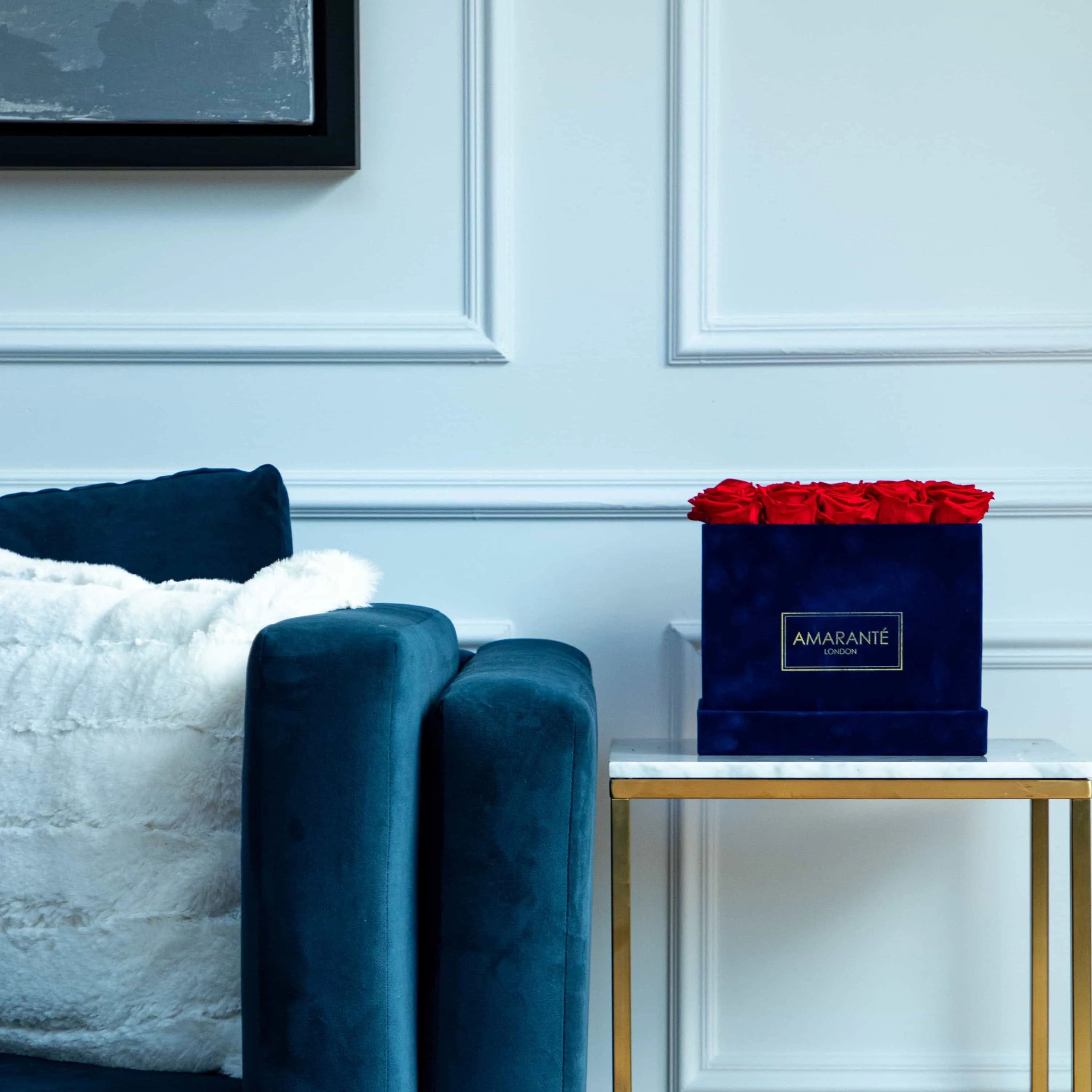 Elevate your home with our blue suede rose box filled with light red infinity roses - adding sophistication and romance to your living space