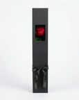 Premium charcoal presentation box displaying single long-stem infinity rose in deep red through front window, adorned with luxury black satin ribbon and gold-embossed tags - Amarante London