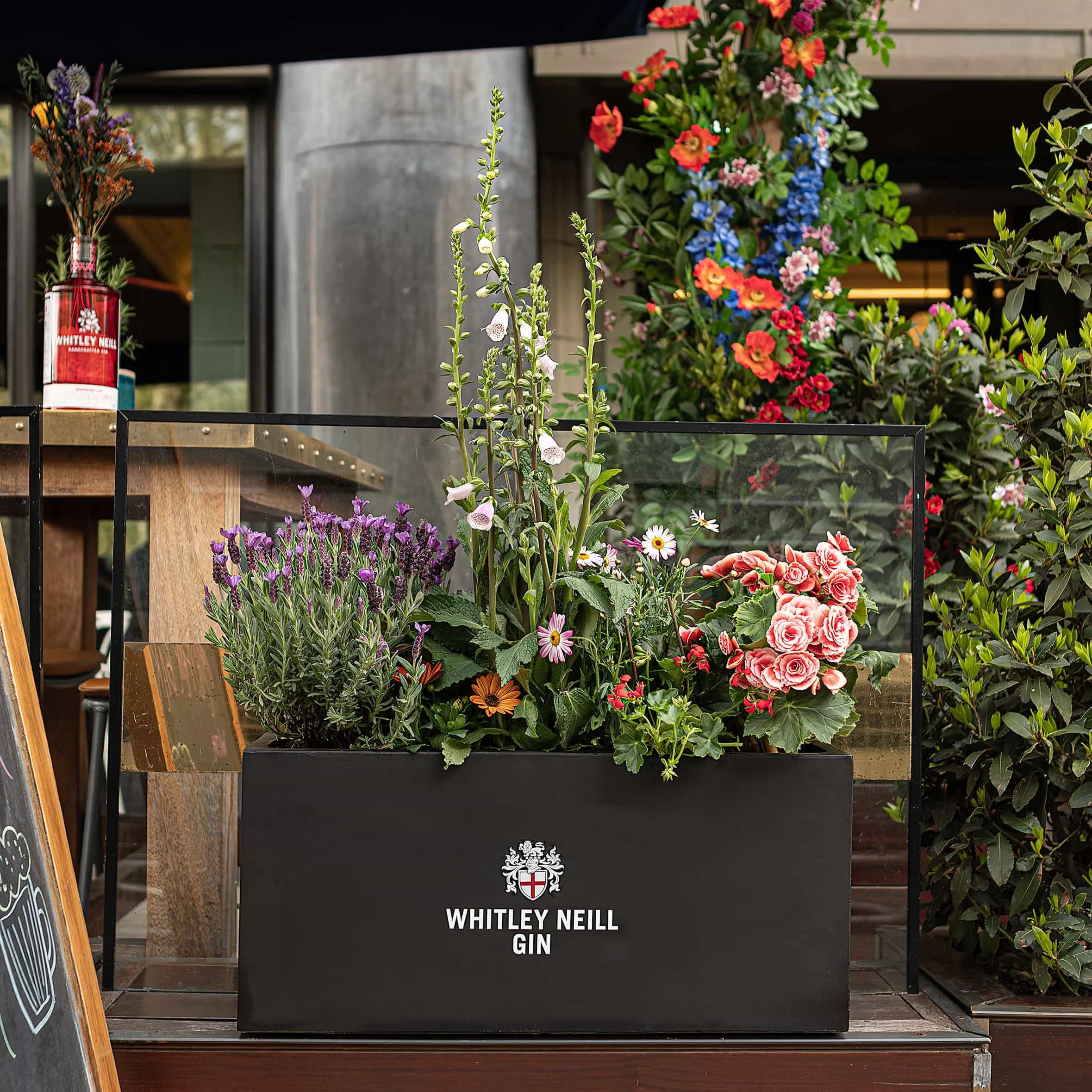 Exterior bespoke floral planters with client Whitley Neill’s logo, installed at Smith & Whistle’s terrace