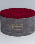 Extra Large Luxury bouquet of 100 deep red infinity roses in an elegant grey round rose box with delicate suede finish. Unique gift for showing timeless love and affection. FreeUK Delivery.