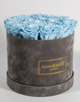 Cool light blue Roses as demonstrated in a stylish grey box