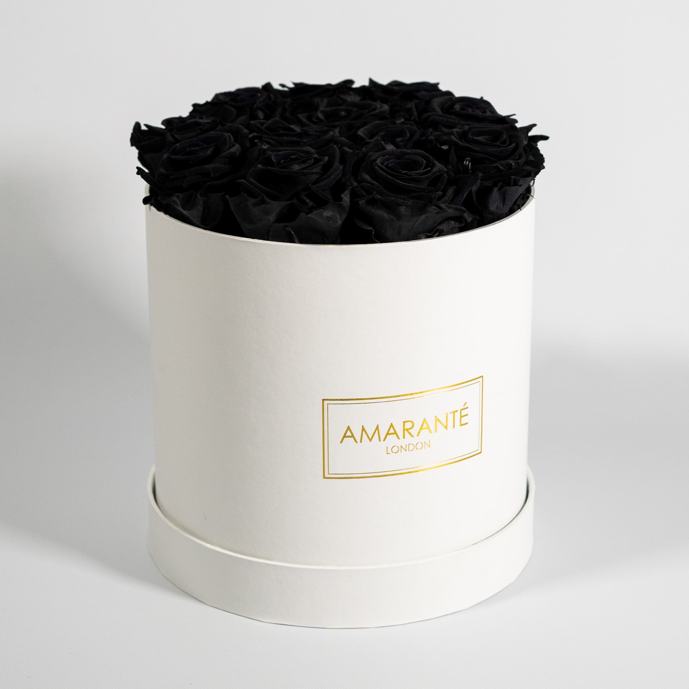 Bold black Roses shown in a dreamy white box