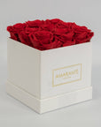 Divine red roses entrenched in a dapper white medium hatbox in square