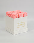 Delicate light pink roses encompassed in a modern white box