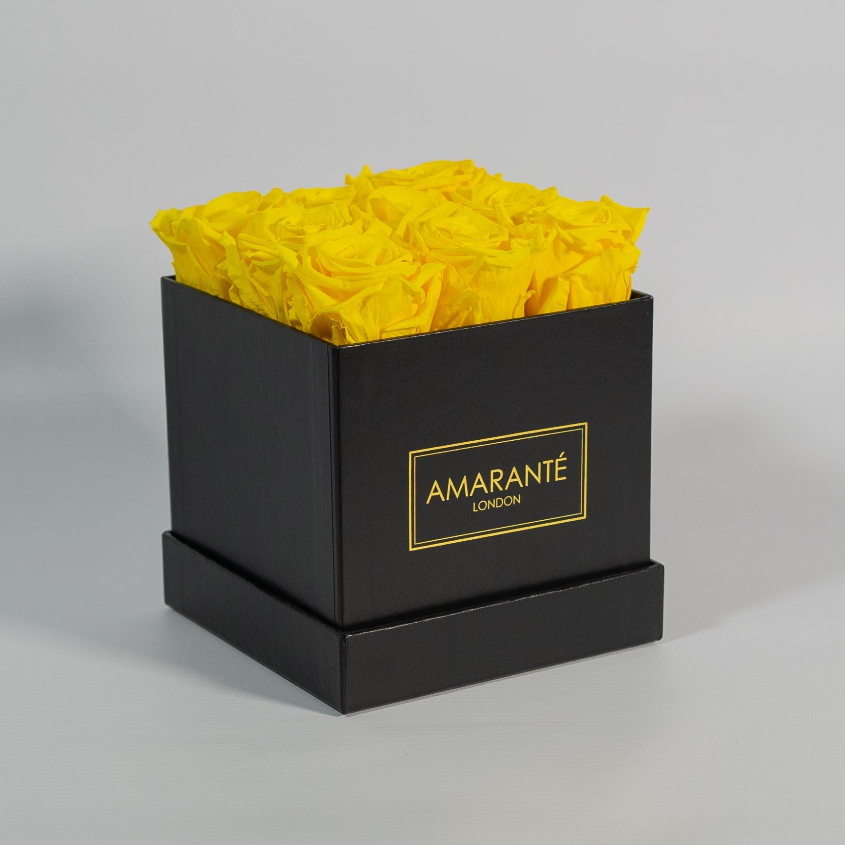 Delightful yellow roses in a magical black box in medium