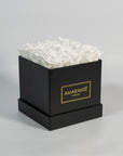 Captivating white roses entrenched in a modish black box