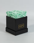 Revitalising mint green roses exhibited in a sleek black box