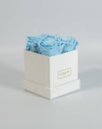 Cool light blue roses featured in a stylish white box