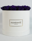 Dapper dark purple Roses comprised in a stunning white large round box
