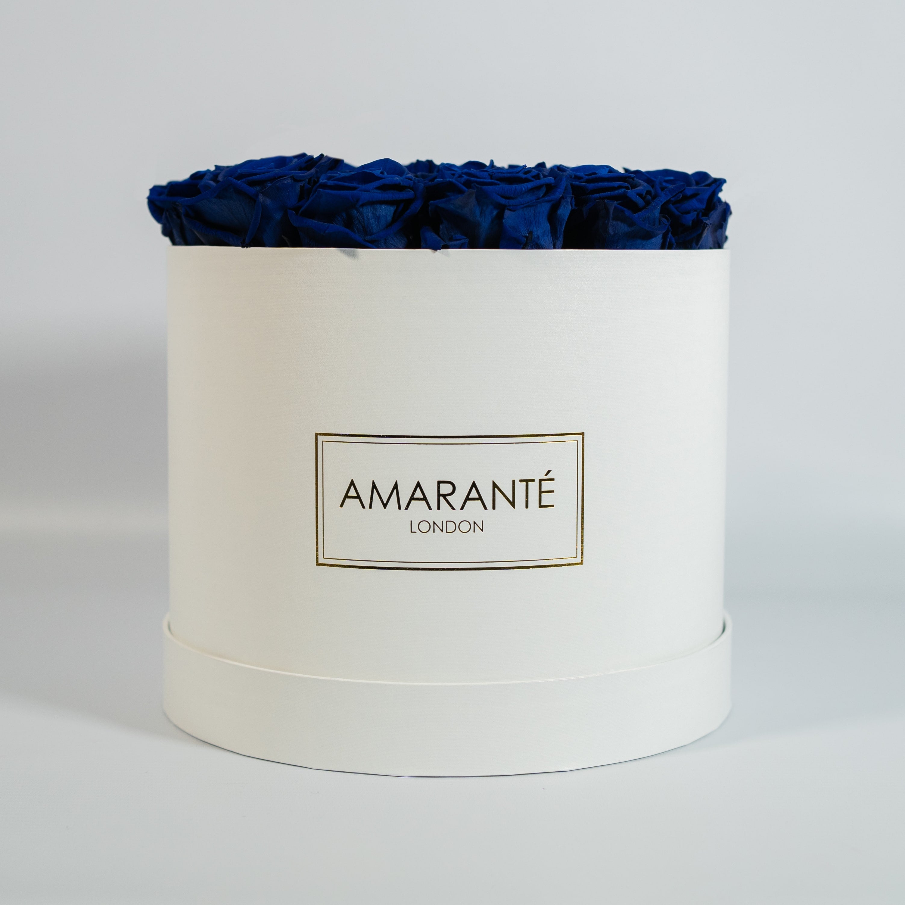 Artistic royal blue Roses displayed in a captivating white box.
