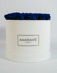 Artistic royal blue Roses displayed in a captivating white box.