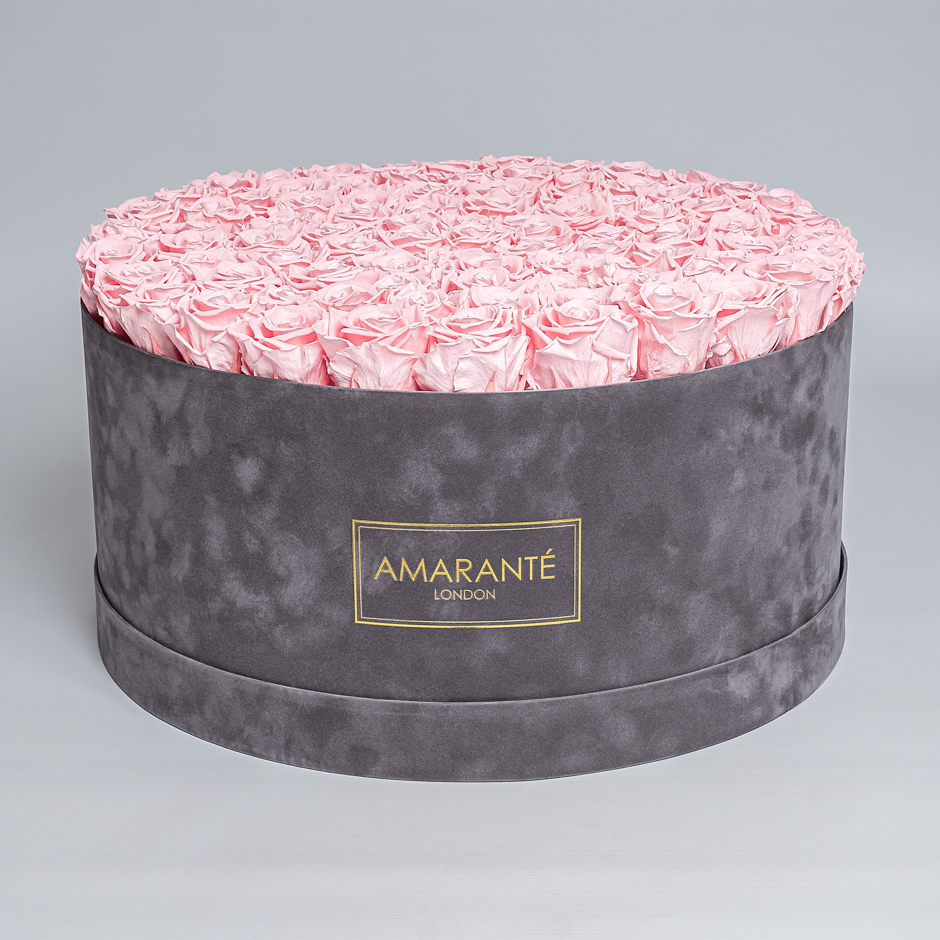 Luxurious grey suede rose box filled with enchanting delicate pink infinity roses showcasing refined style and grace. Ideal for family and friends that appreciate trendy and classy gifts on special occasions. Free UK Delivery.