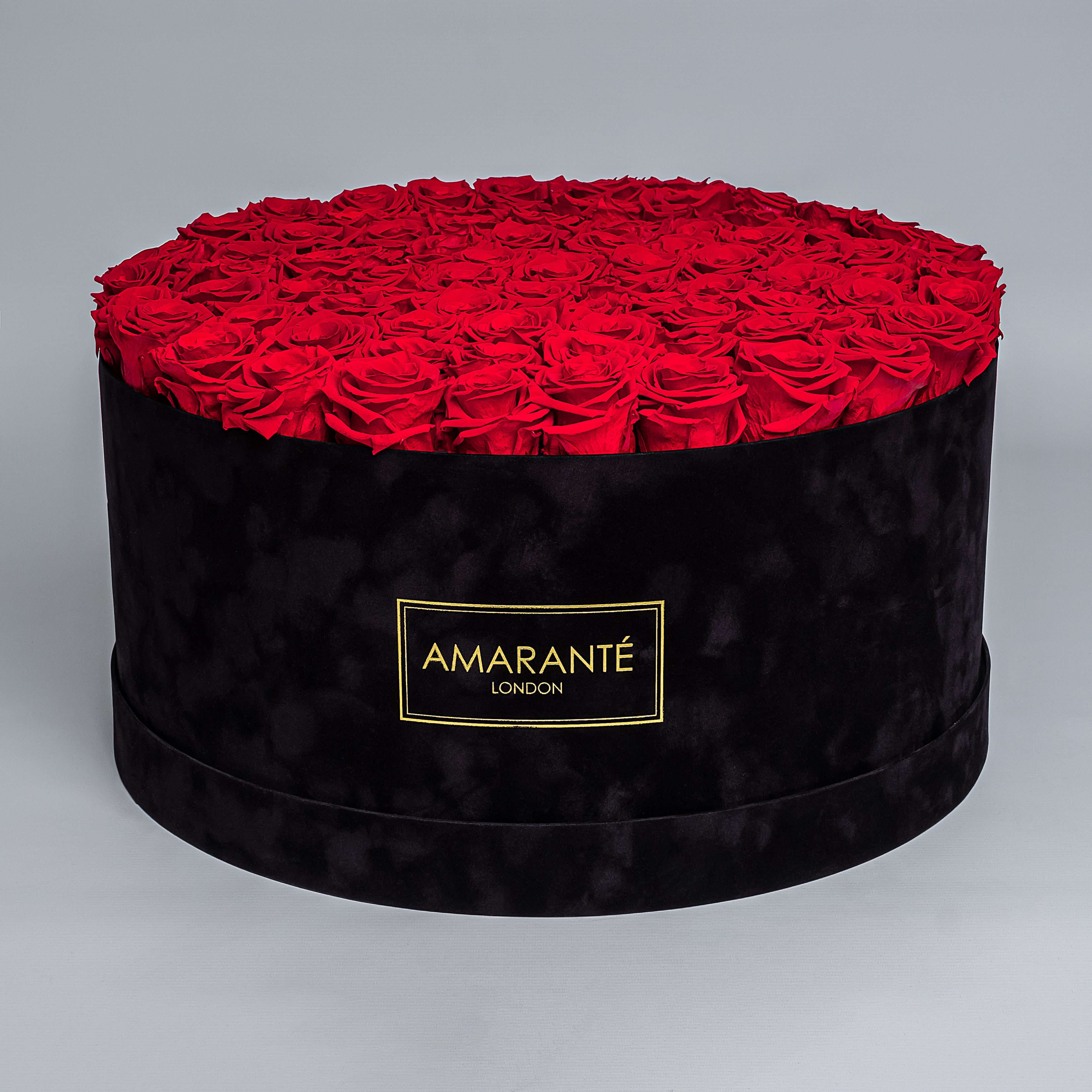 Mesmerising bouquet of 100 light red infinity roses nestled in a black round rose box with delicate suede finish. Exquisite gift for showing timeless love and affection. FreeUK Delivery.