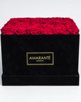 36 Bright red infinity roses elegantly placed in an extra large black suede hatbox. Free UK Delivery.