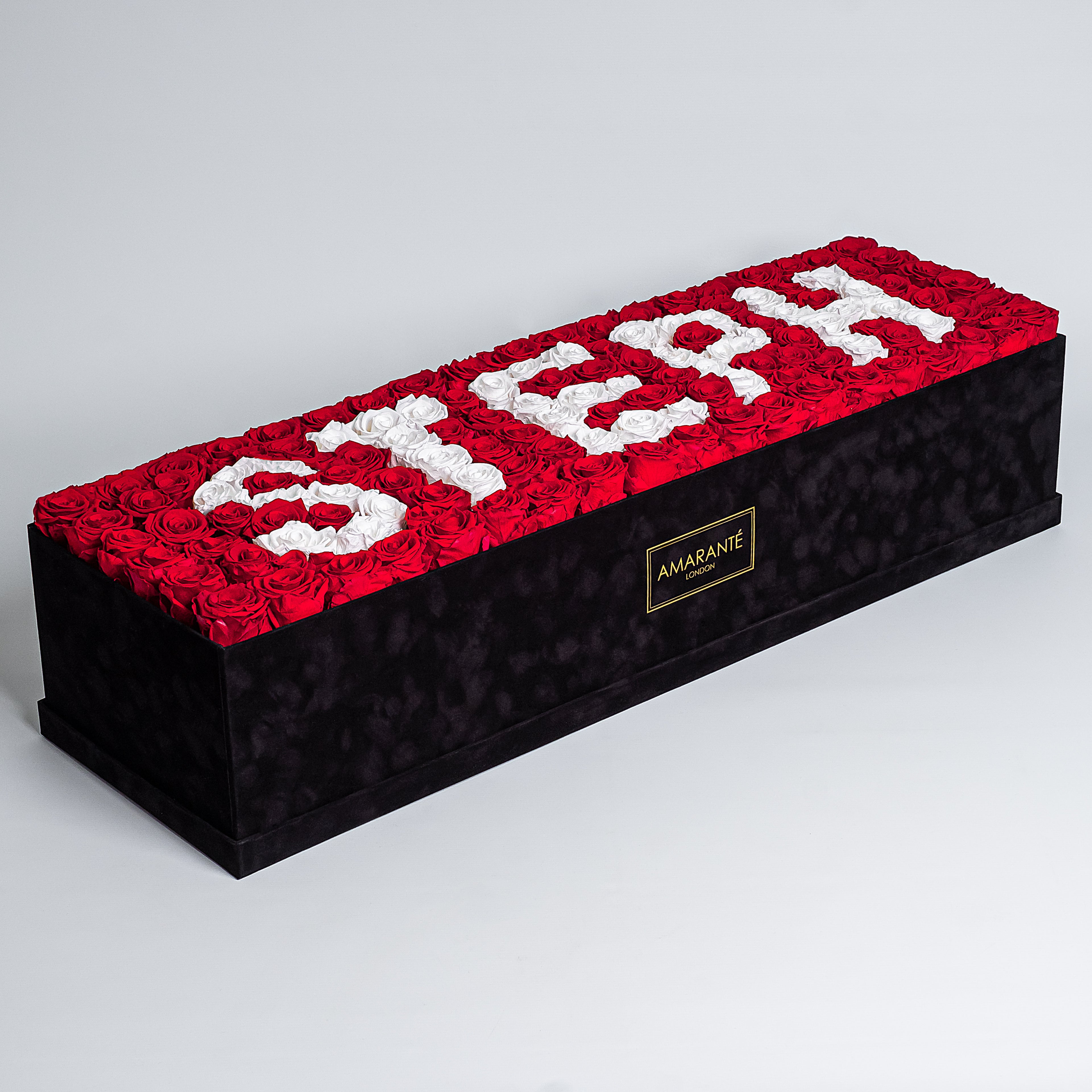 Captivating super deluxe black rectangular rose box, refined with a suede finish, housing 140 chic red and white infinity roses, symbolising enduring love with the name STEPH. Free UK delivery, Box size: 30"x25".