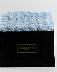 Sophisticated arrangement of light blue forever roses in a suave square black suede hatbox.