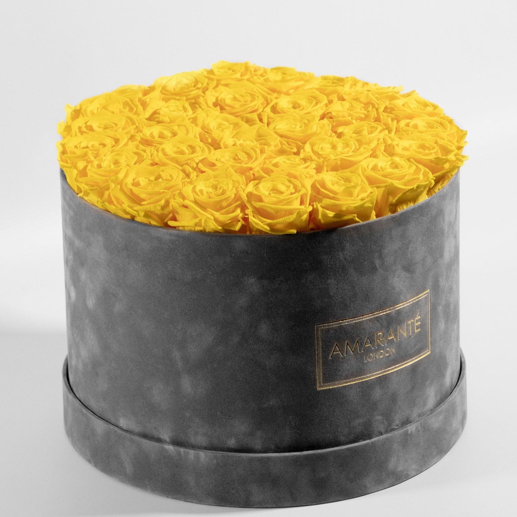 Delightful yellow Roses in a vogueish grey package denoting friendship and warmth.