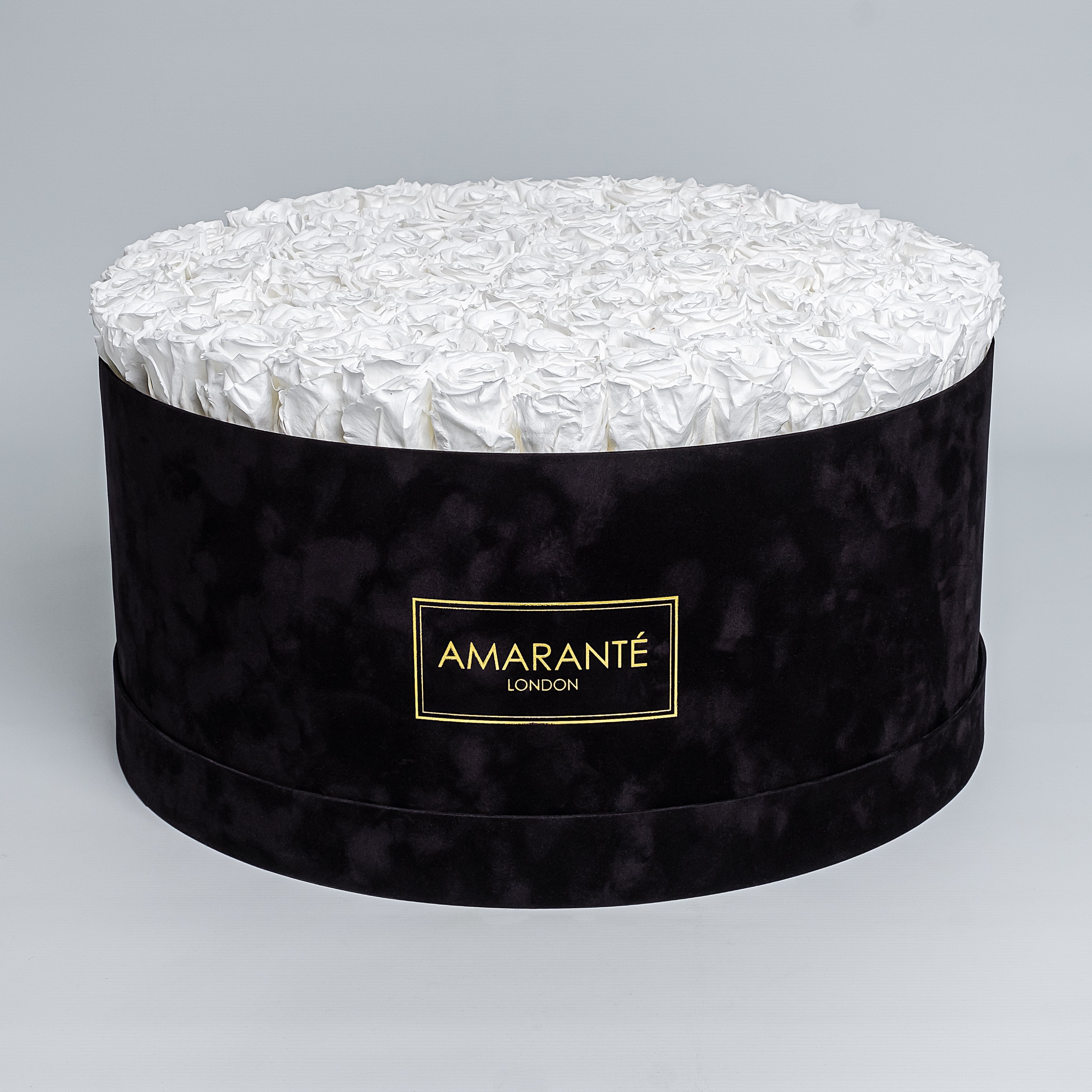 Elegant display of pure white forever roses in a chic black hatbox with delicate suede finish, symbolising enduring elegance and sophistication. Perfect for gifting to loved ones on Birthdays, Anniversaries, Valentine's Day or other special events of everyday life. Free UK delivery.