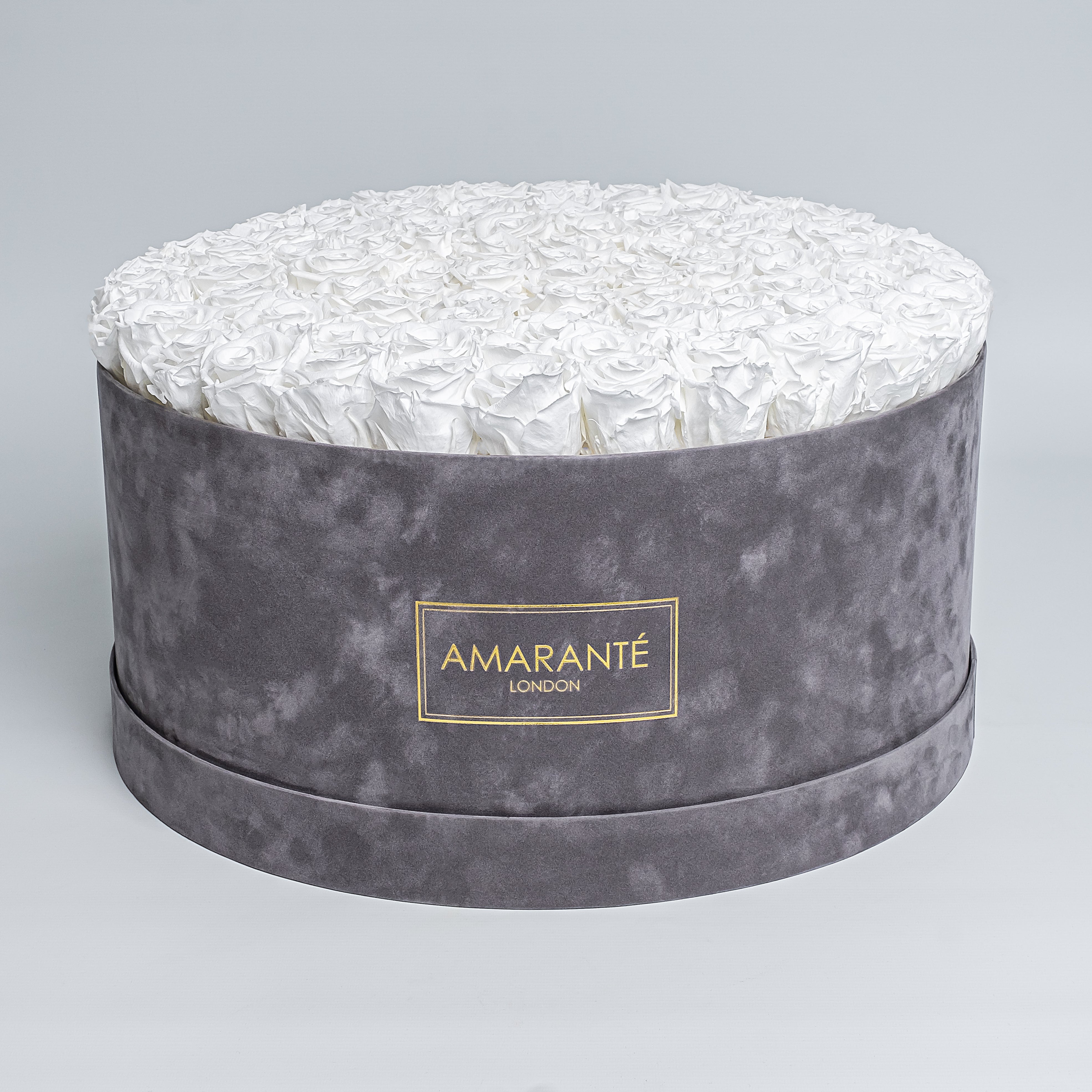 Elegant display of pure white forever roses in a chic grey hatbox with delicate suede finish, symbolising enduring elegance and sophistication. Perfect for gifting to loved ones on Birthdays, Anniversaries, Valentine's Day or other special events of everyday life. Free UK delivery.