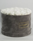 Dapper white Roses in a stylish grey box, denoting clarity, simplicity, and class.