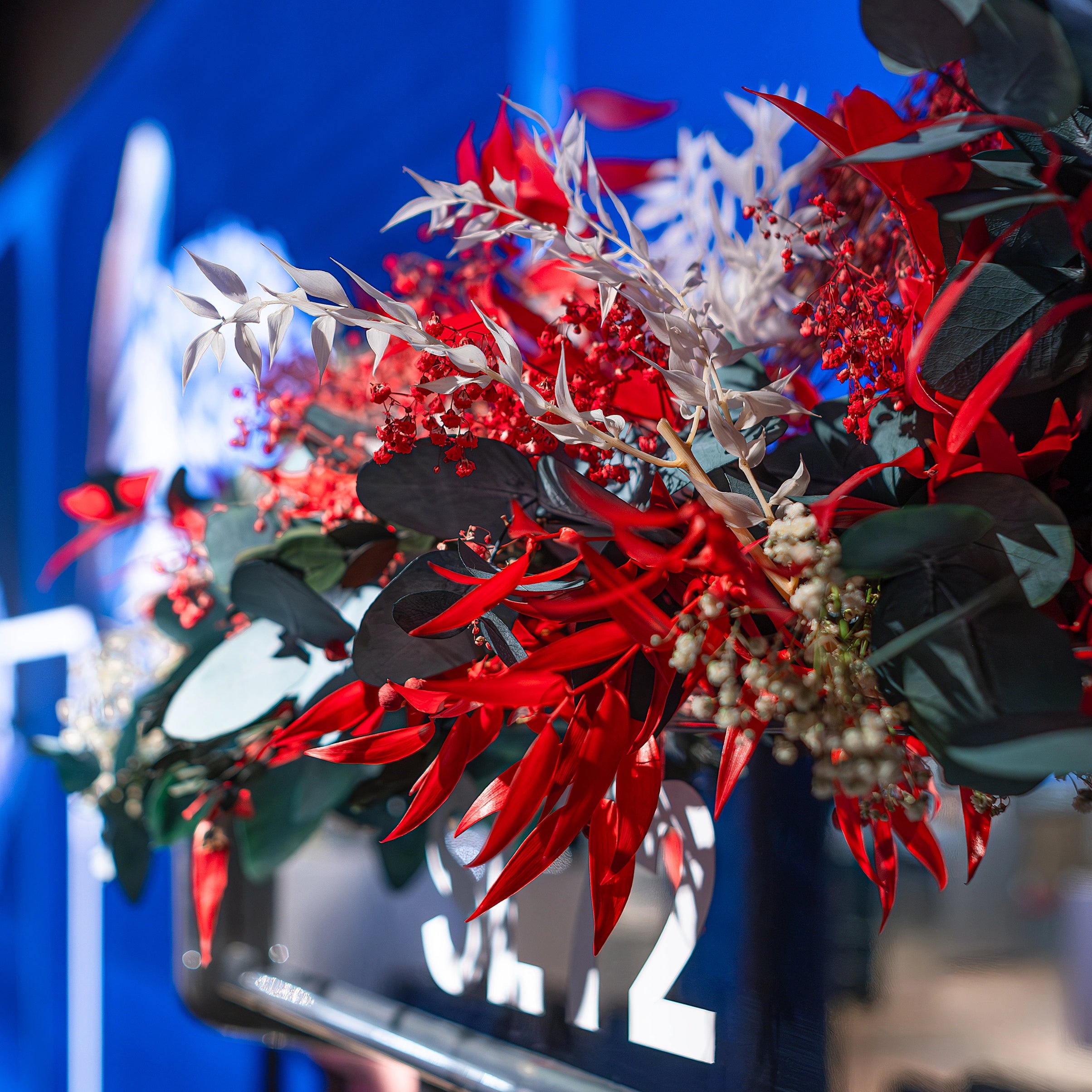 Floral Design for the Adidas Bond Street store created by Event Florist Amaranté London. This is an image of a flower arrangement highlighting the red foliage intertwined with green leaves to align with the atmosphere of the SL72 collection launch.