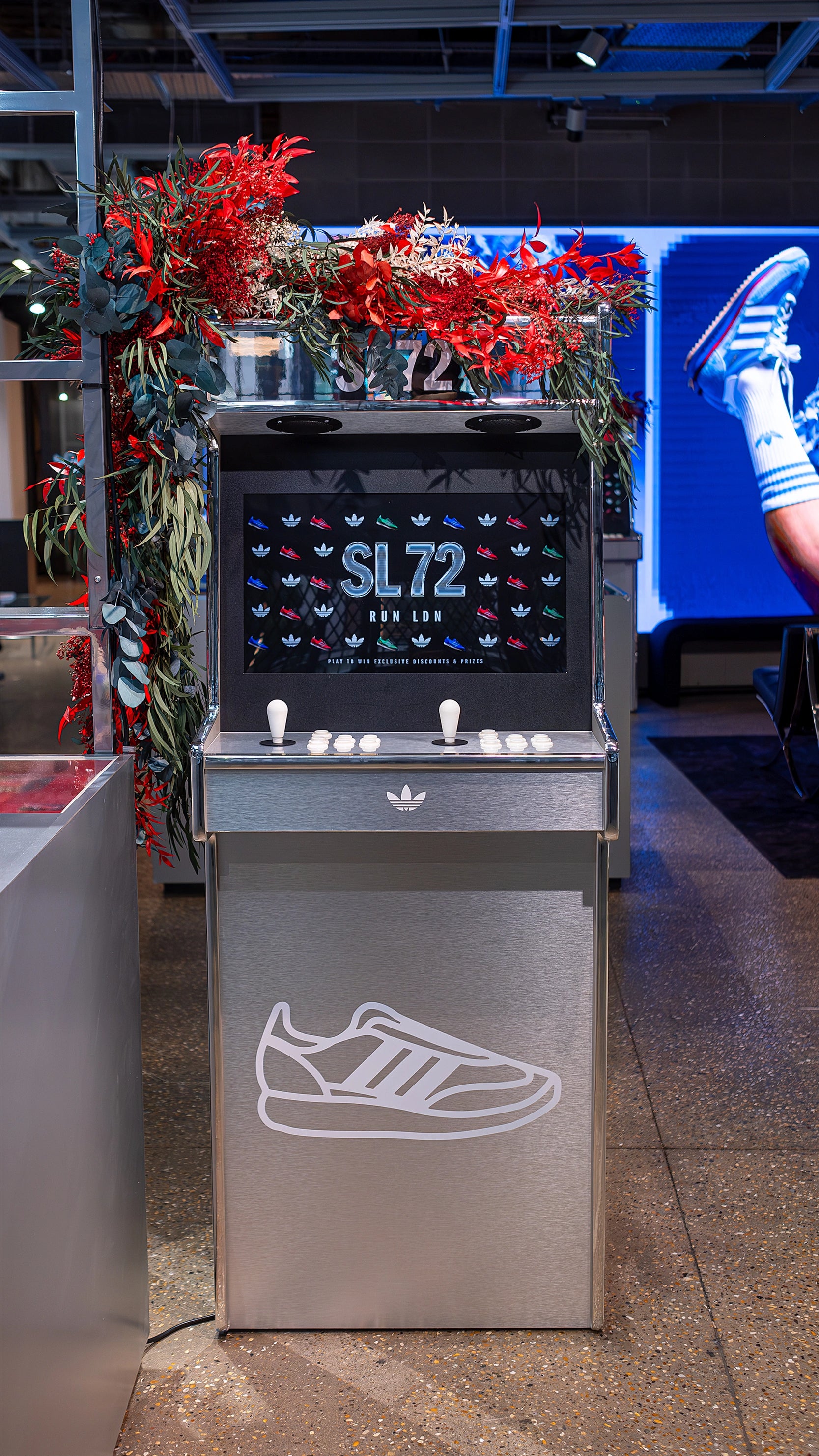 A Bespoke floral installation at the Adidas Bond Street store, designed to enhance the SL72 collection’s retail presentation with vibrant red and green floral arrangements - Floral Desgin by Amaranté London, Event Florist