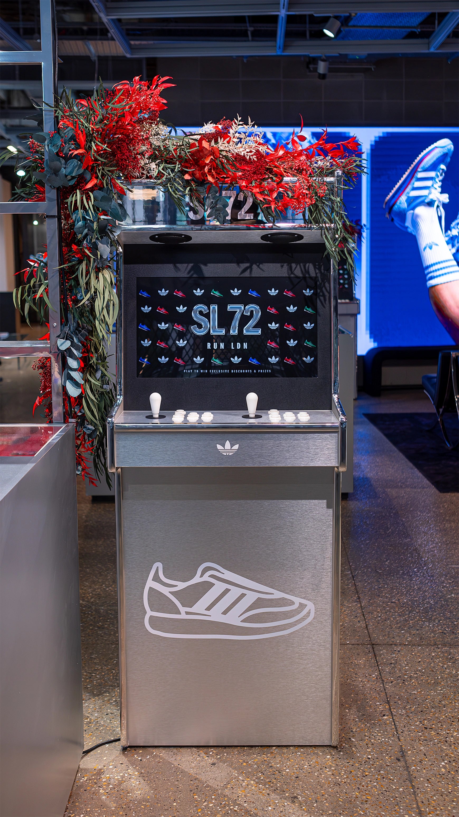 A Bespoke floral installation at the Adidas Bond Street store, designed to enhance the SL72 collection’s retail presentation with vibrant red and green floral arrangements - Floral Desgin by Amaranté London, Event Florist