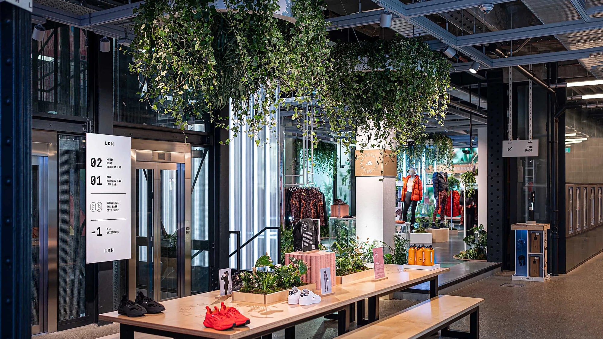 The entire retail environment is transformed by the presence of plants and greenery for the Adidas x Stella McCartney aSMC launch by Amaranté London - experienced Event Florist. The trailing ivy adorns the ceiling, and a curated collection of plants enriches the urban space with a natural, serene atmosphere.