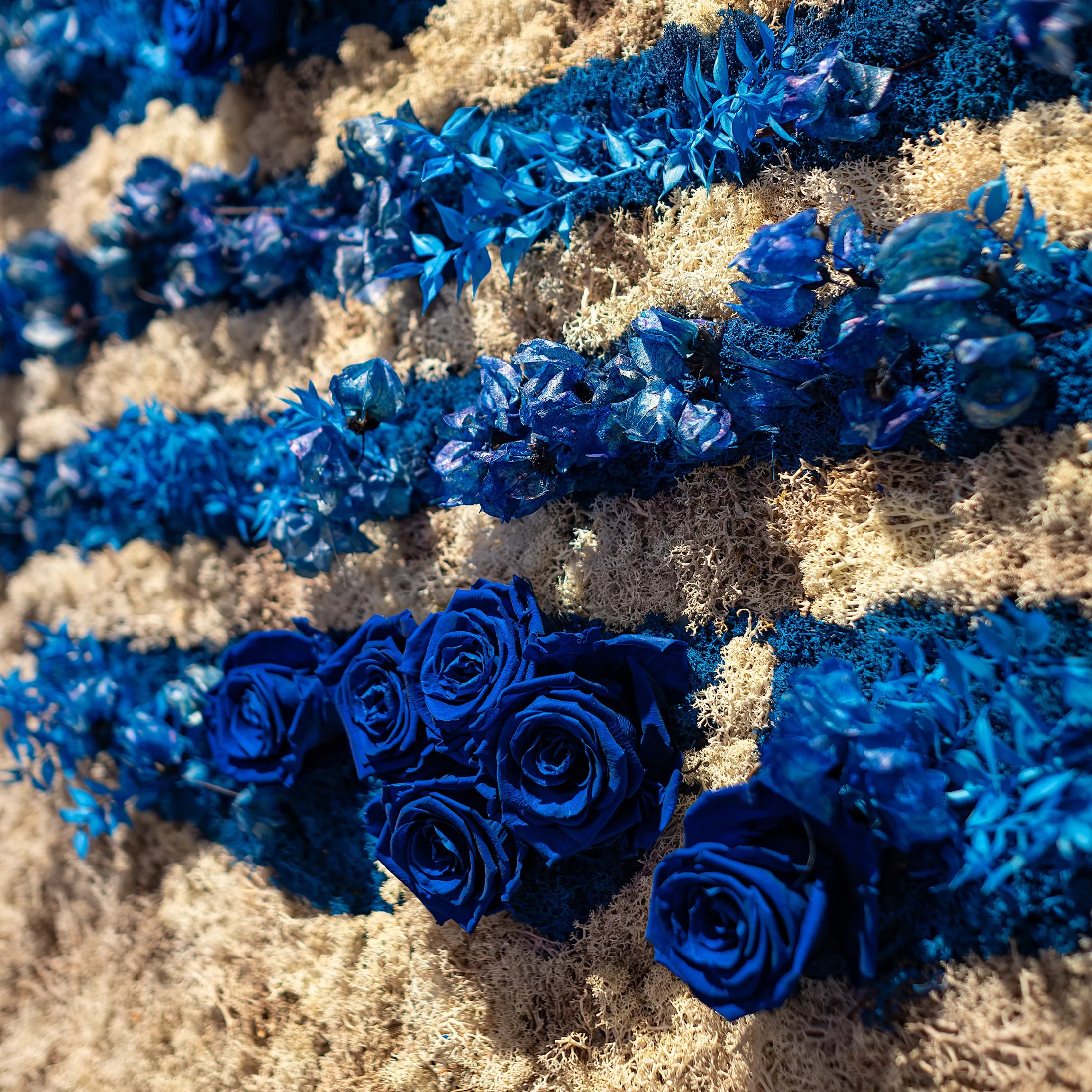 Close-up of Adidas logo recreated with blue infinity roses and moss. The intricate floral arrangement highlights the brand's identity while attracting shoppers attention to the new collection of shoes - Amaranté London