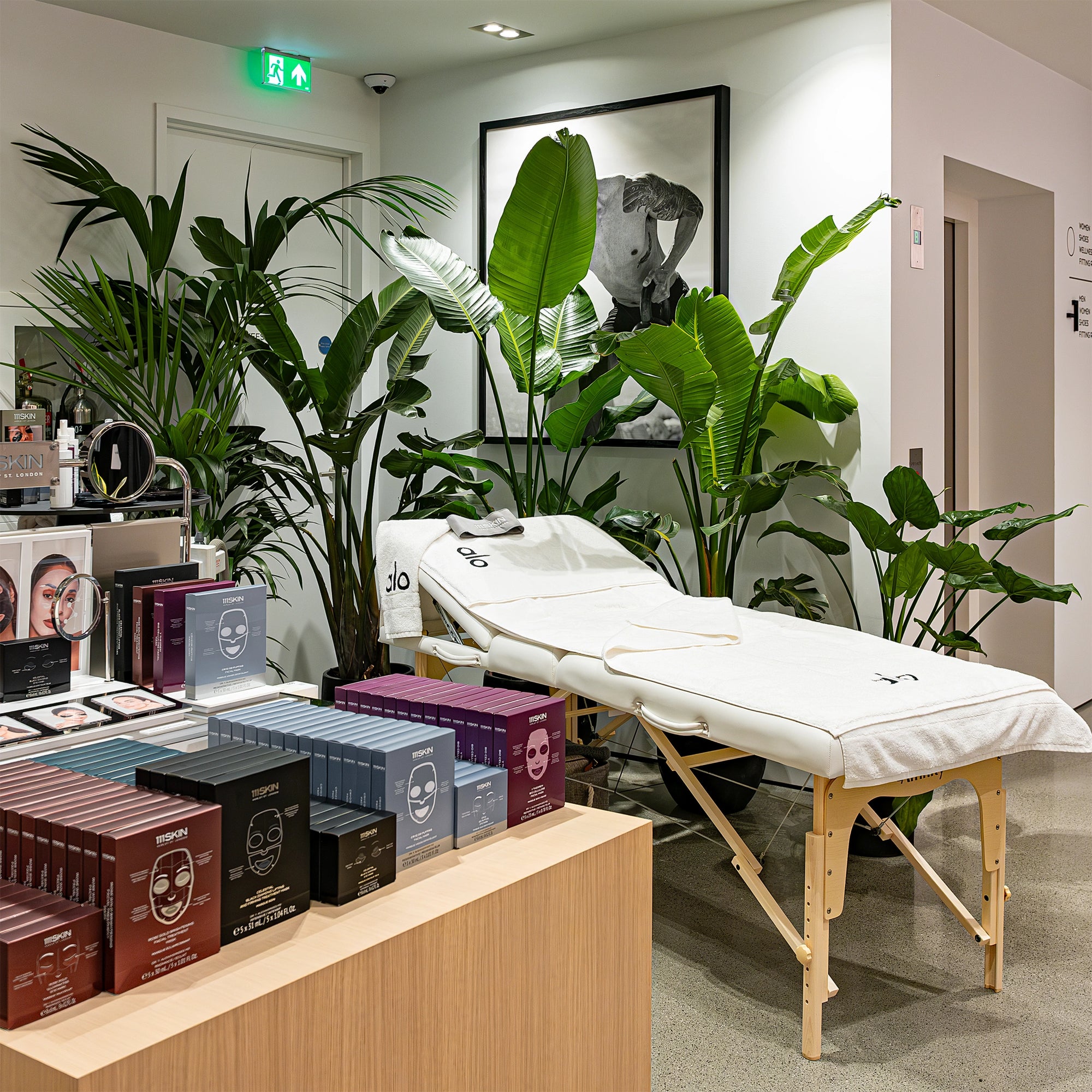 A chic floral arrangement featuring white hydrangeas and lush green foliage on a countertop at Alo Regent Street Store Grand Opening, designed by Amaranté London. Luxury Floral arrangements that add elegance and sophistication to the wellness and fitness store space.