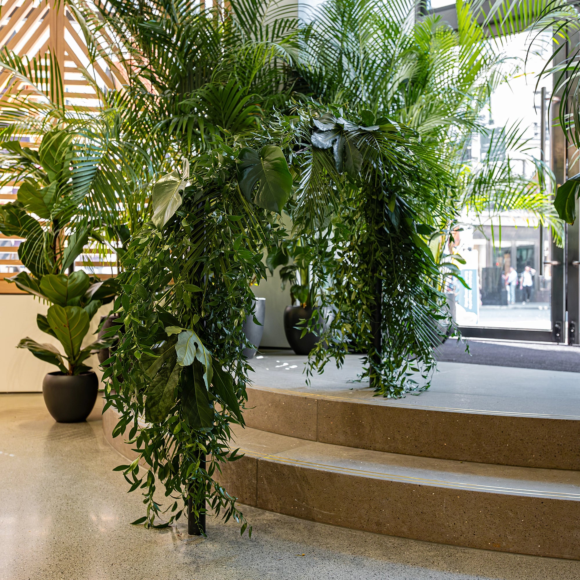 A beautifully designed tropical foliage arch featuring Monstera and Birds of Paradise leaves by Event Florist Amaranté London was installed for the Alo Regent Street Store's Grand Opening. The lush, green arch is a striking entrance feature, creating a grand and inviting first impression for store visitors.