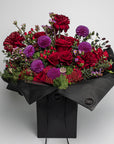 An exquisite Valentine's Day Bouquet of fresh flowers featuring a mesmerising arrangement of luxurious roses in captivating shades of crimson red and dazzling purple, juxtaposed with refined verdant green foliage. This elegant, timeless flower arrangement sends a sophisticated message of love and affection. Free UK delivery on this stylish, classy and enchanting fresh flower bouquet. Perfect choice for Vday Flowers, expressing timeless elegance and chic sophistication in a graceful, polished style.