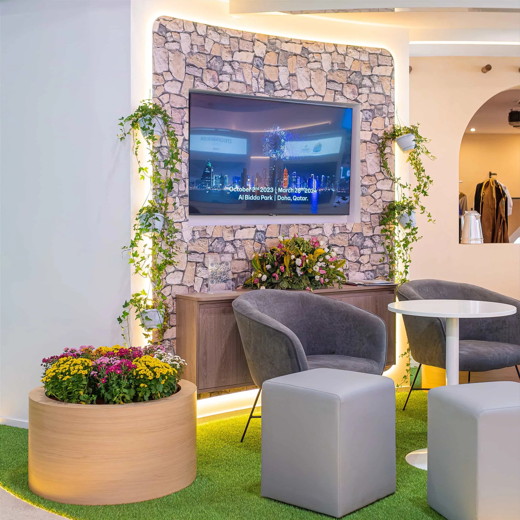 Amaranté London's floral finesse on display at WTM, with a stone wall backdrop adorned with ivy and a terracotta pot featuring an assortment of bright fresh flowers.