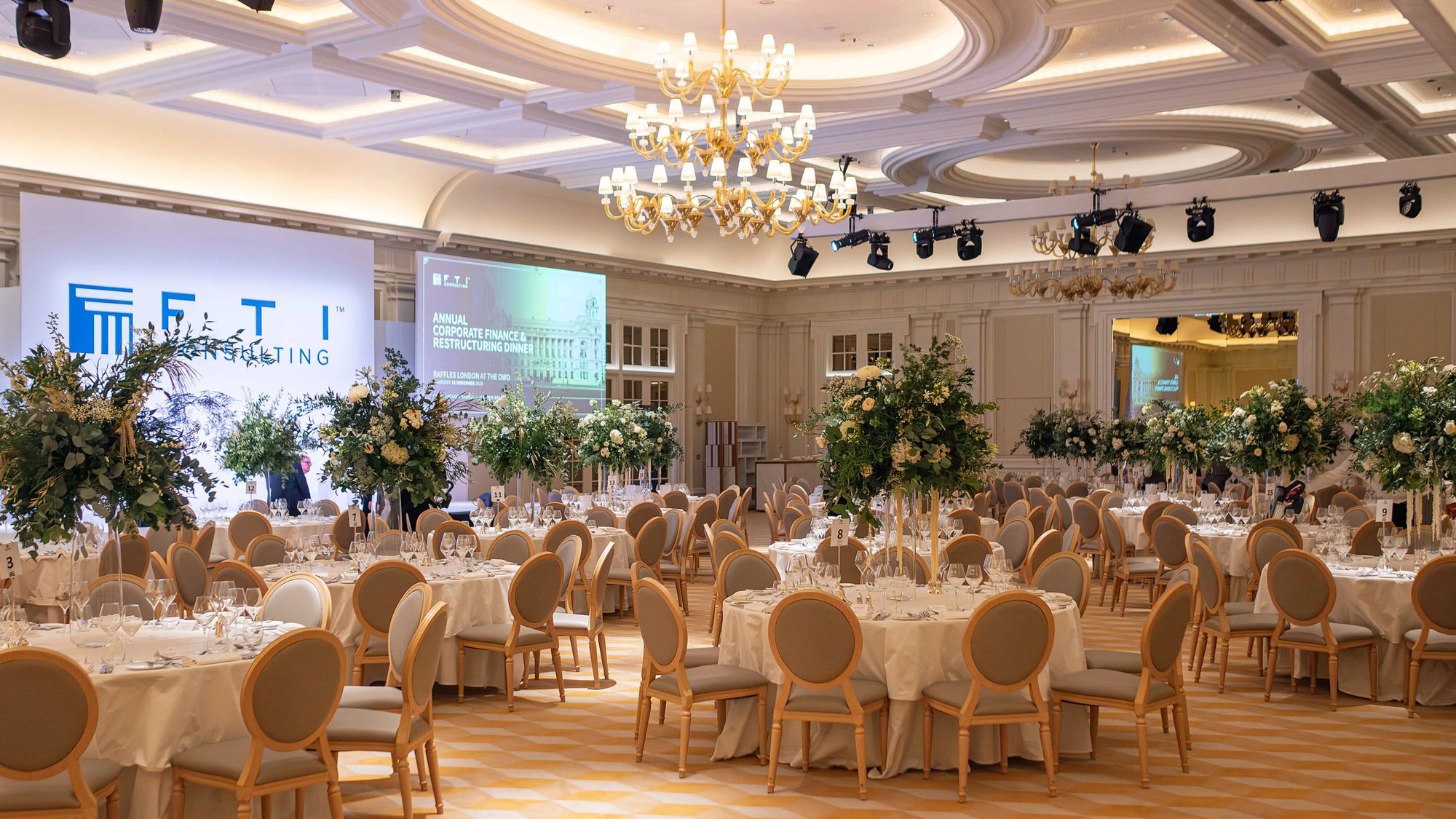 The grand ballroom at Raffles London at the OWO, set up for the FTI Consulting Annual Corporate Finance and Restructuring Dinner, showcases a blend of sophistication and natural elegance with bespoke floral arrangements by Amaranté London - Flowers for Corporate Events.
