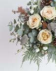 Bouquet of flowers with roses, eucalyptus, and other greenery on a light background