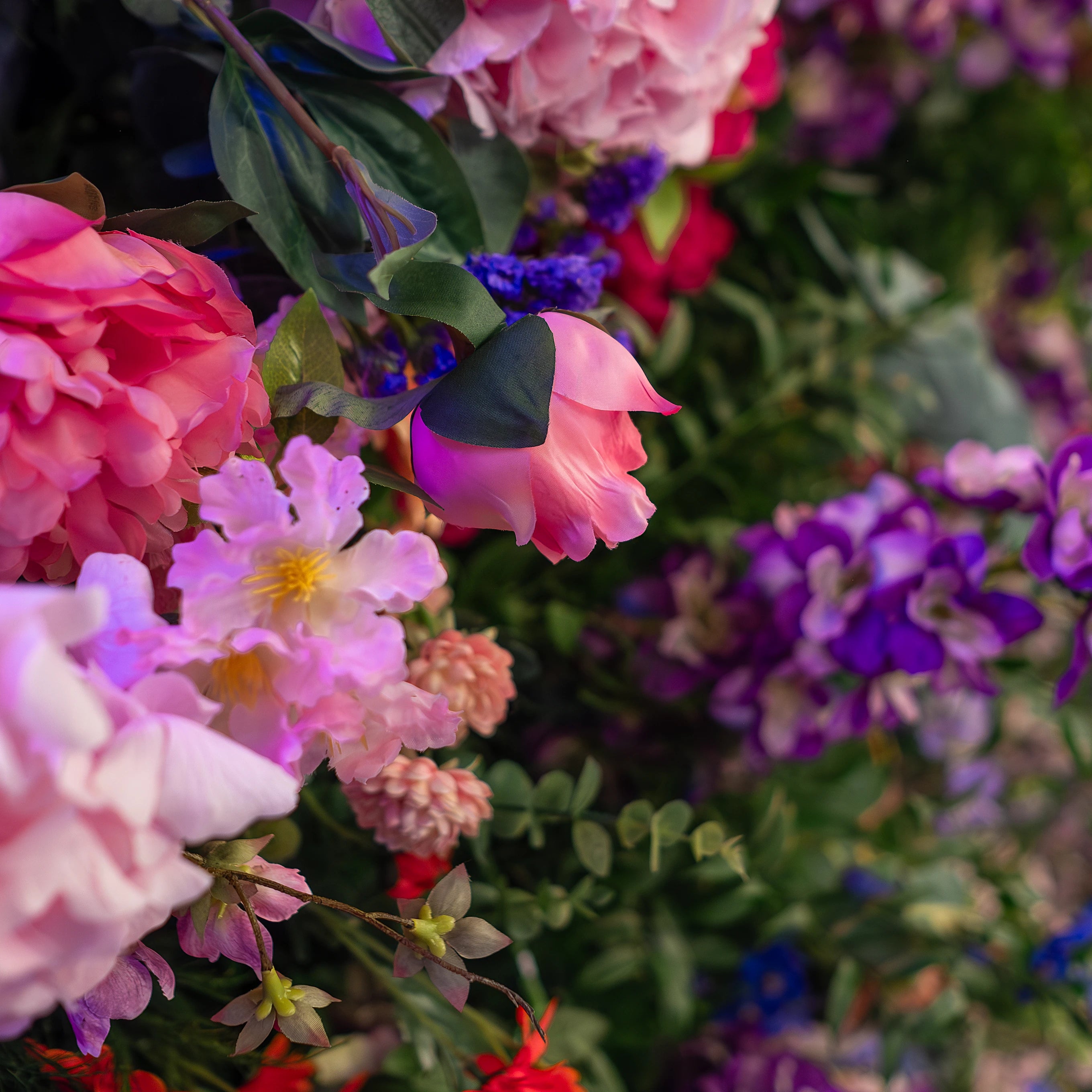 Vivid close-up of a flower arrangement at the Formula E Gala Dinner Event in London, featuring pink peonies, white hydrangeas, and blue and purple blooms, with a focus on texture and colour depth, crafted, designed and installed by Event Florist Amaranté London.