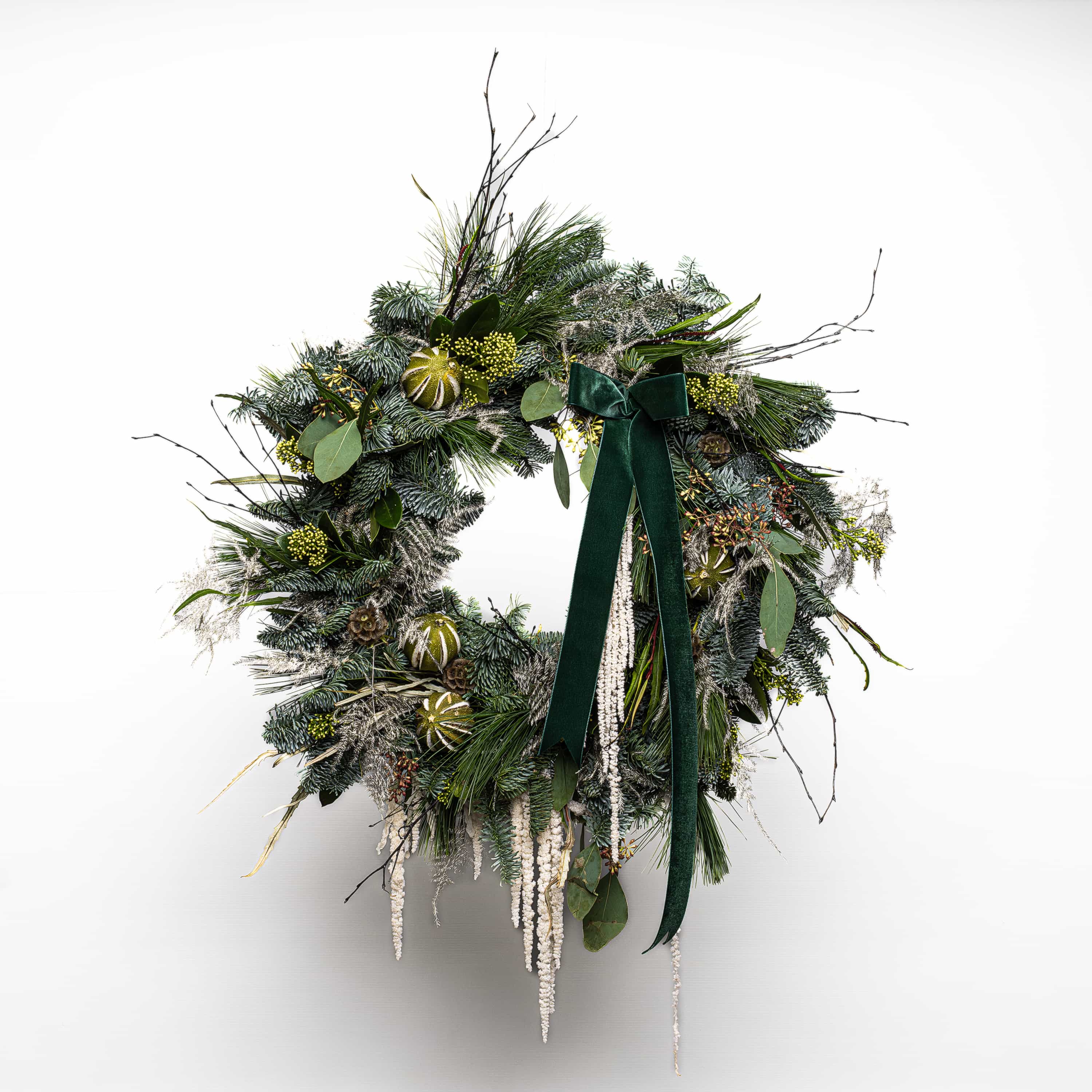 Christmas wreath adorned with lush green foliage and festive yellow trimmings - Amaranté London