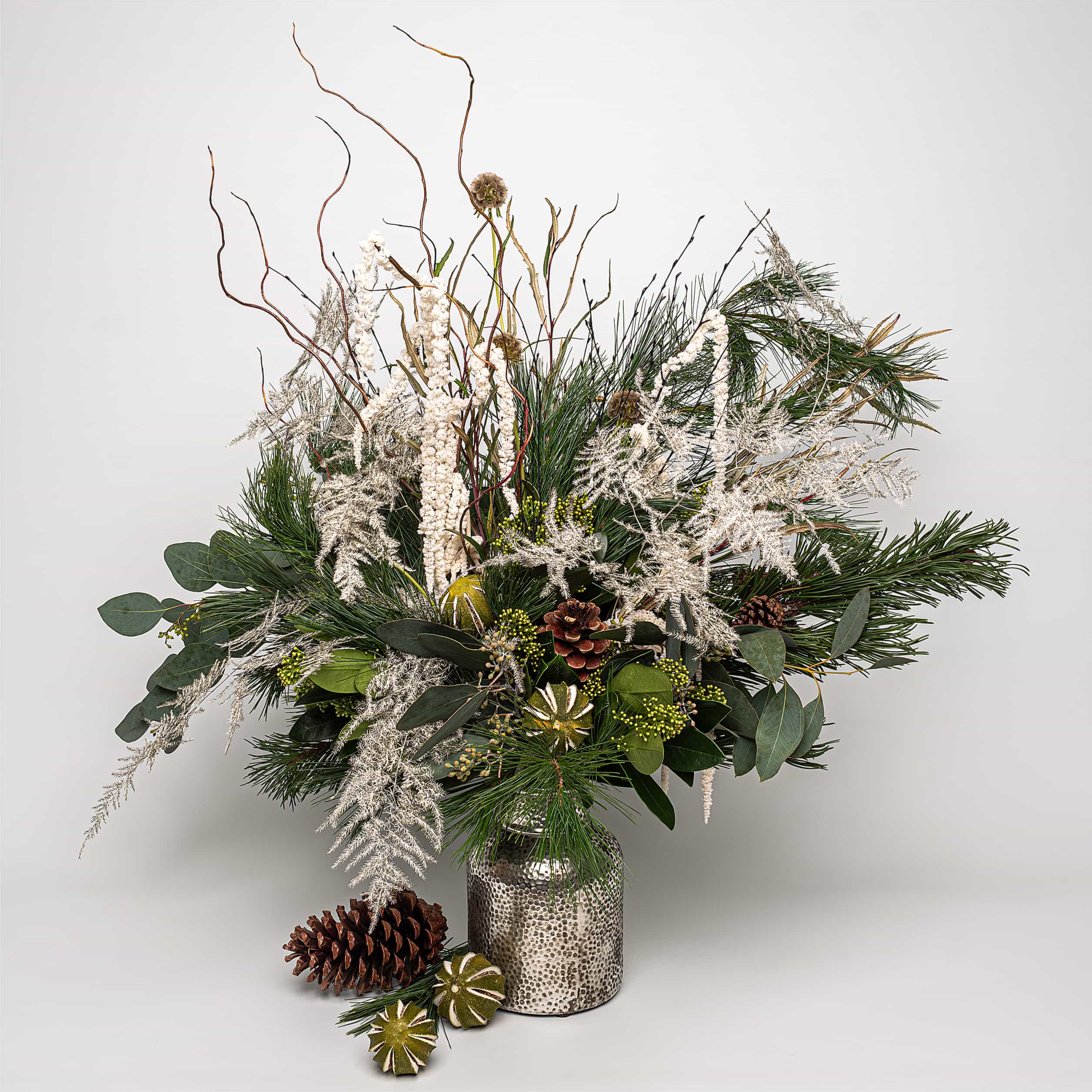 Luxurious Christmas bouquet: vibrant whites, deep greens, and the rustic elegance of pine cones - Amaranté London