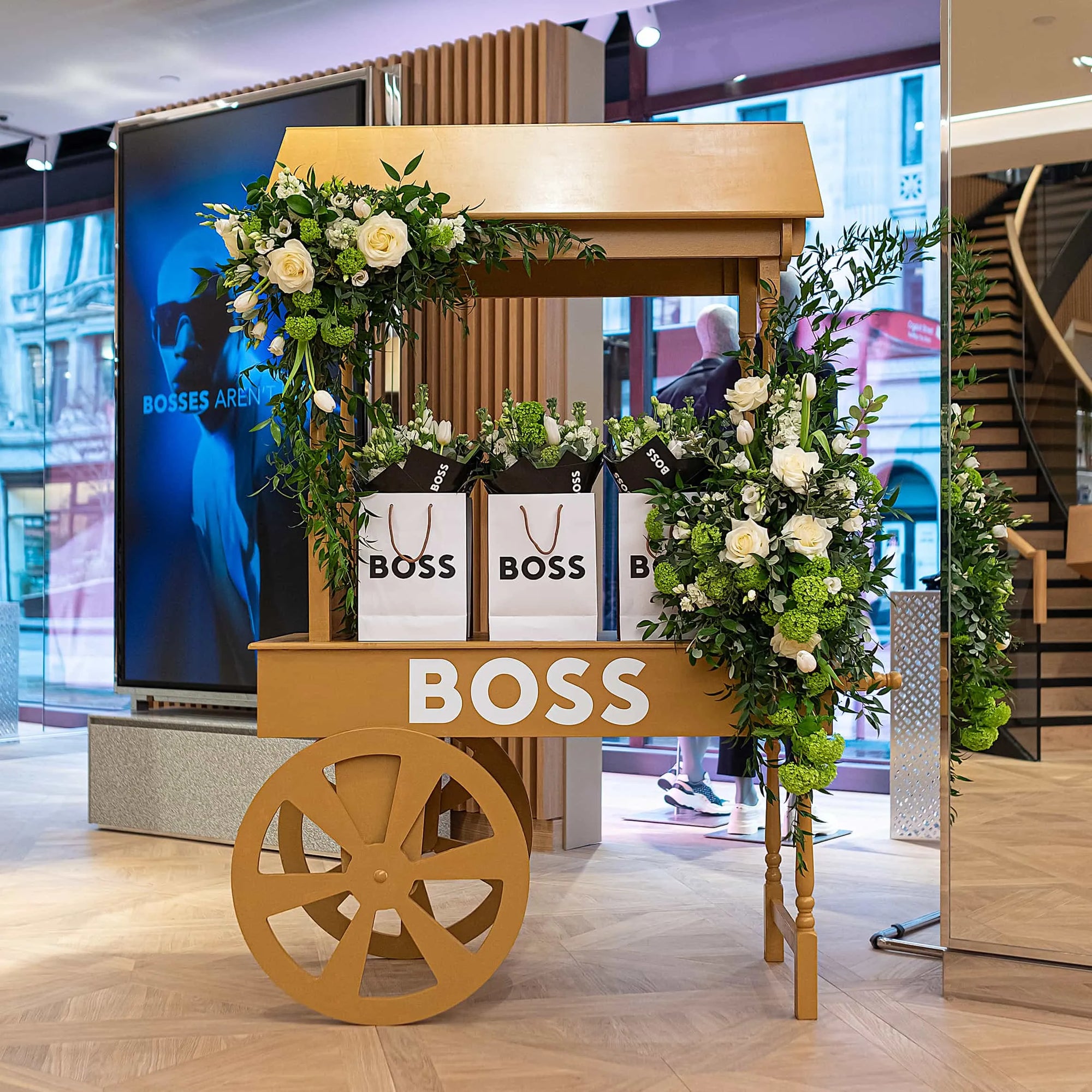 Floral cart installation with white roses and seasonal greenery, created for Hugo Boss London in-store event by Amarante London