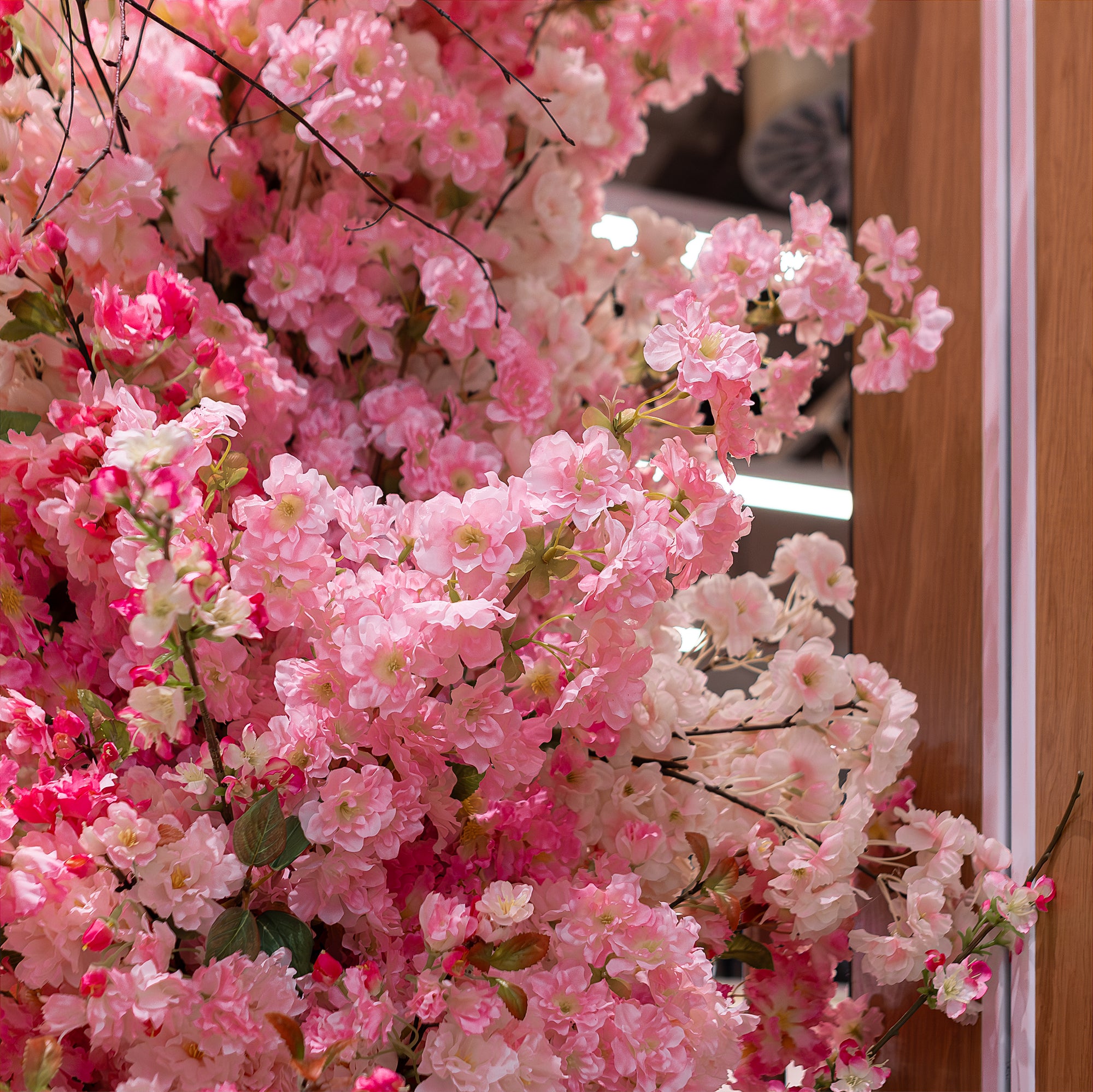 Close-up view of the cherry blossom floral arch, designed, created, and installed by event florist Amaranté London at Ichiba Japan Centre. The detailed arrangement showcases vibrant pink and delicate white cherry blossoms, intricately arranged to mimic natural cherry blossom trees. This floral arrangement adds a touch of Japanese elegance to the Ichiba Japan Centre Food Hall entrance in London, creating a visually stunning entrance that impresses and attracts visitors.