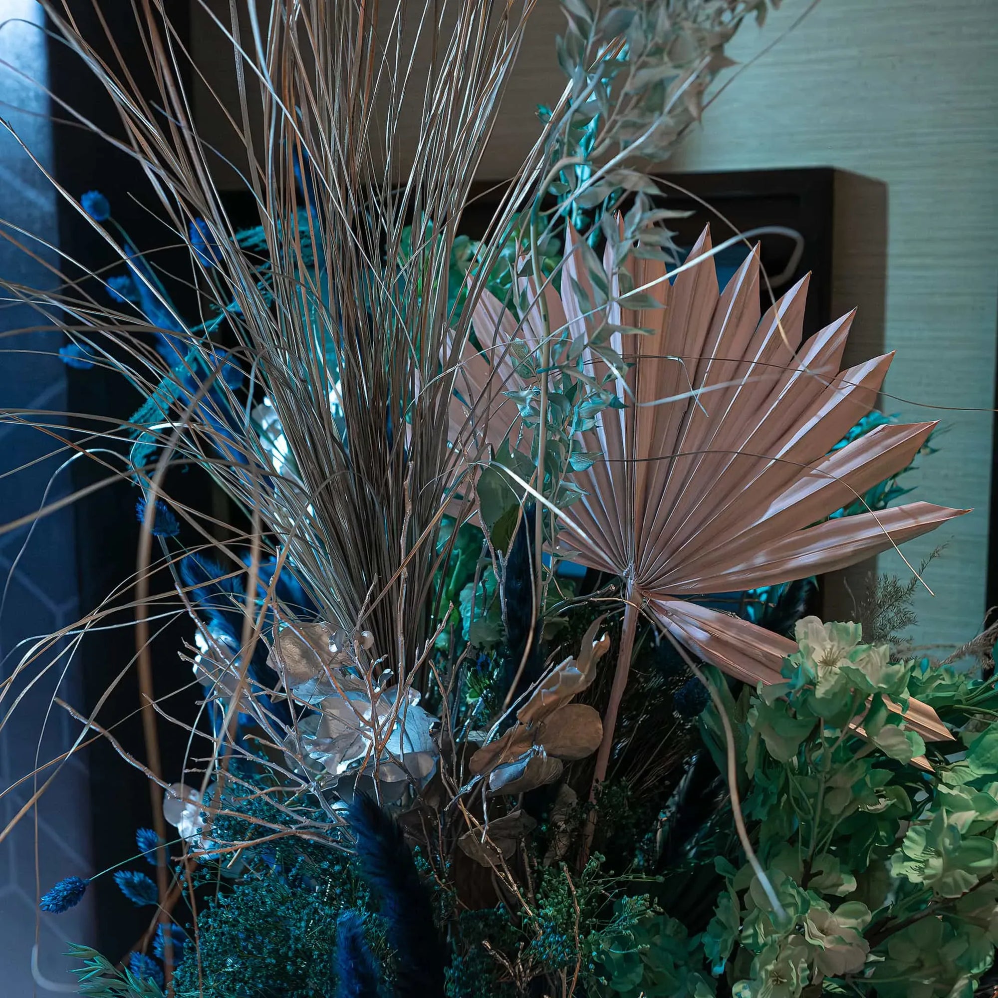 Elegant Christmas floral display by Amaranté London for the InMode event at Nobu Hotel. Includes dried palm leaves, silver branches, and green foliage, arranged in a sophisticated composition enhancing the corporate event’s decor.