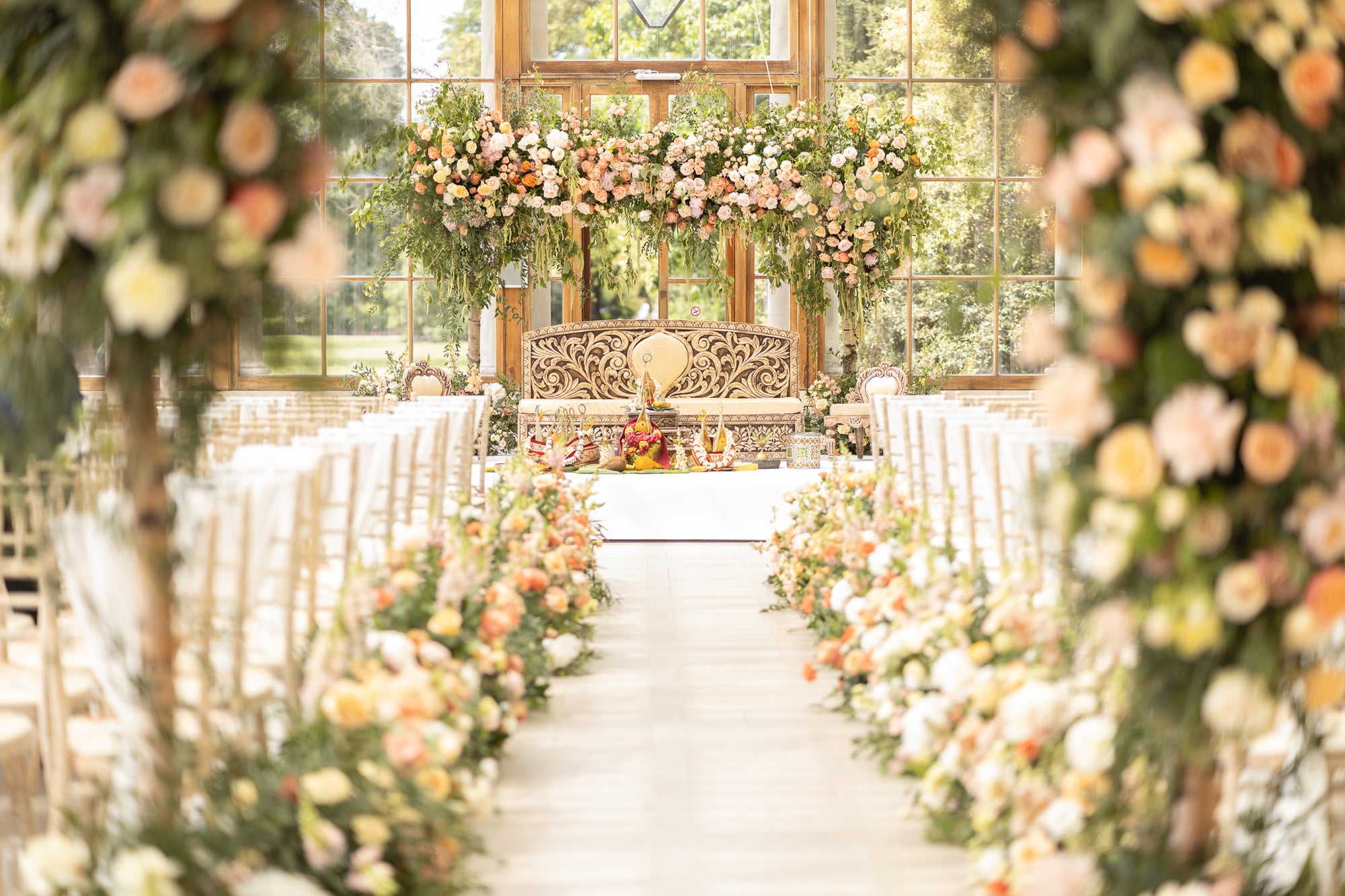 Luxury wedding ceremony with bespoke floral installations by Amaranté London production house at glass conservatory venue
