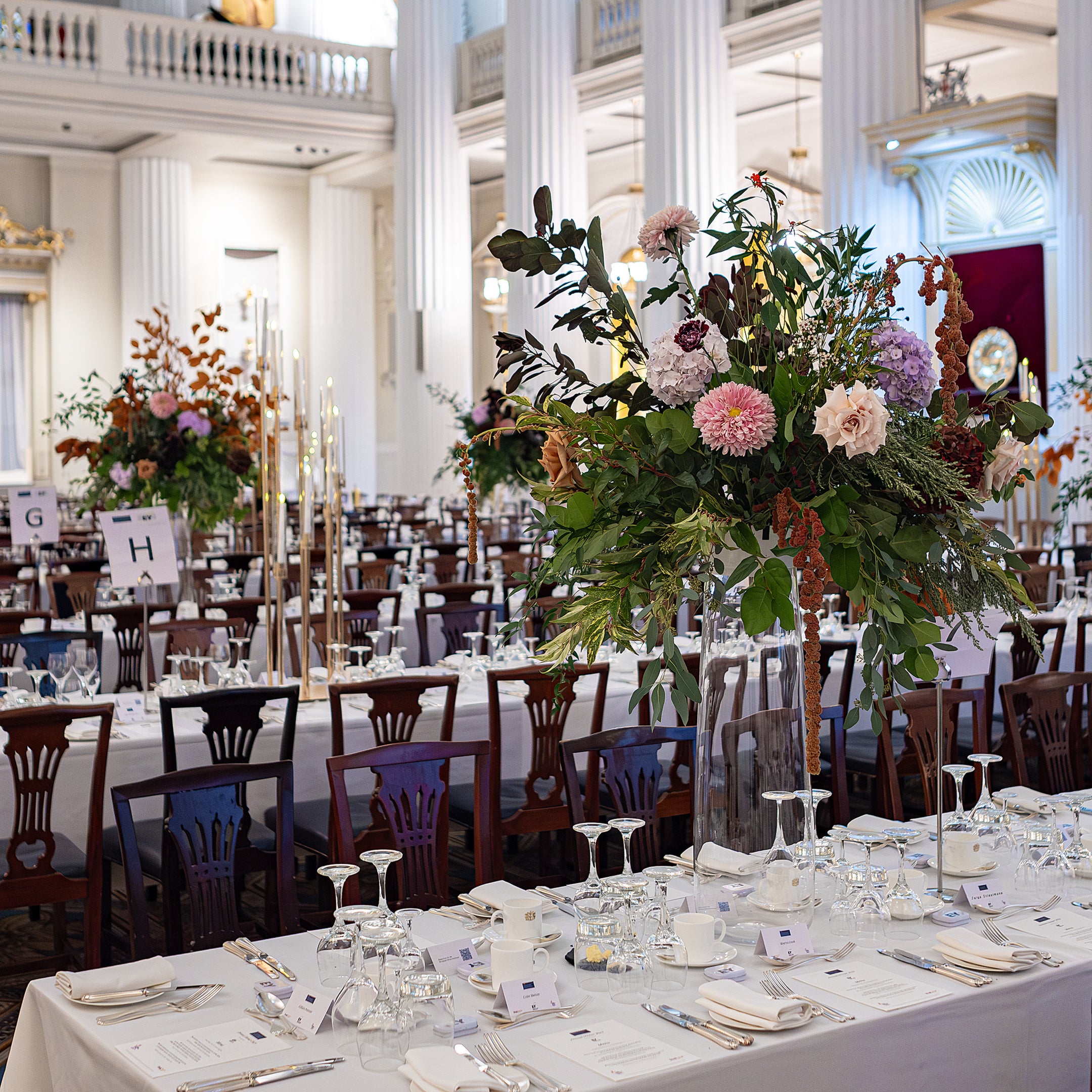 Bespoke arrangements in tall vases, made to captivate the elegantly of the decorated dining room