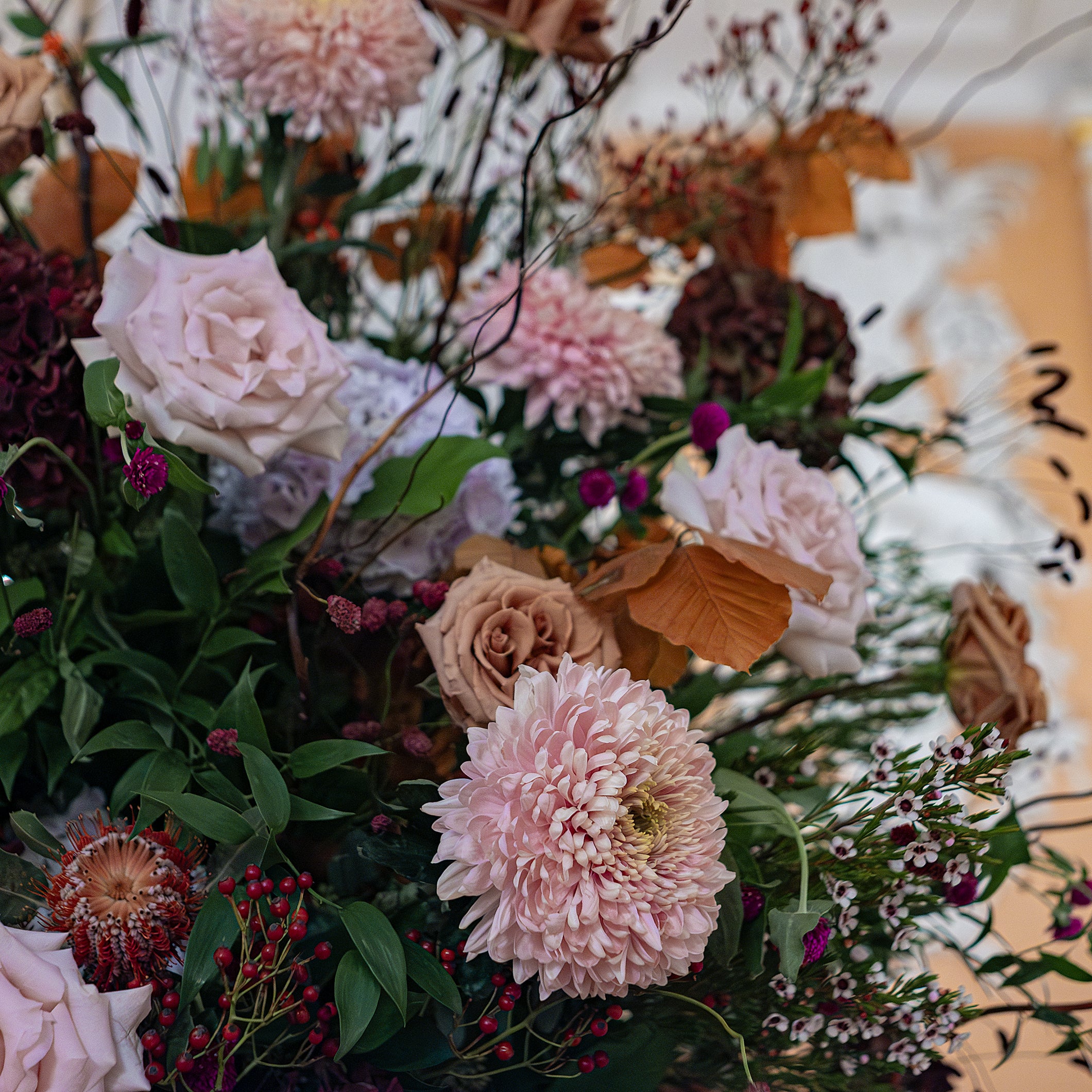 Detailed view of bespoke floral arrangement with pink, green, and light brown stems and flowers