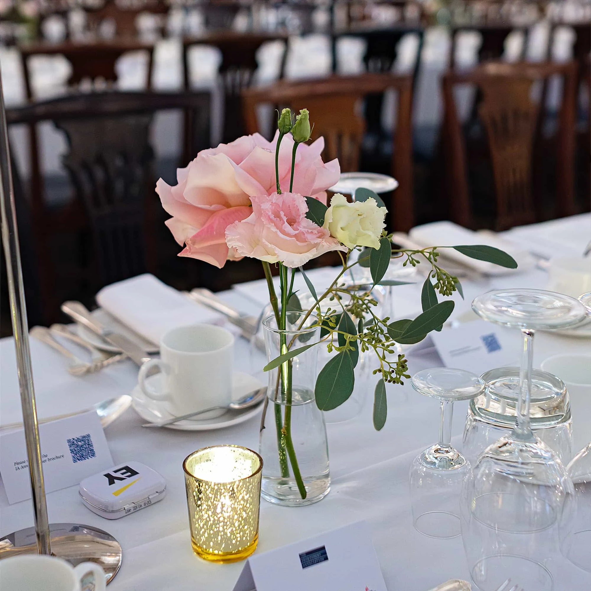 A lone rose in a jar adorning a spacious dining table