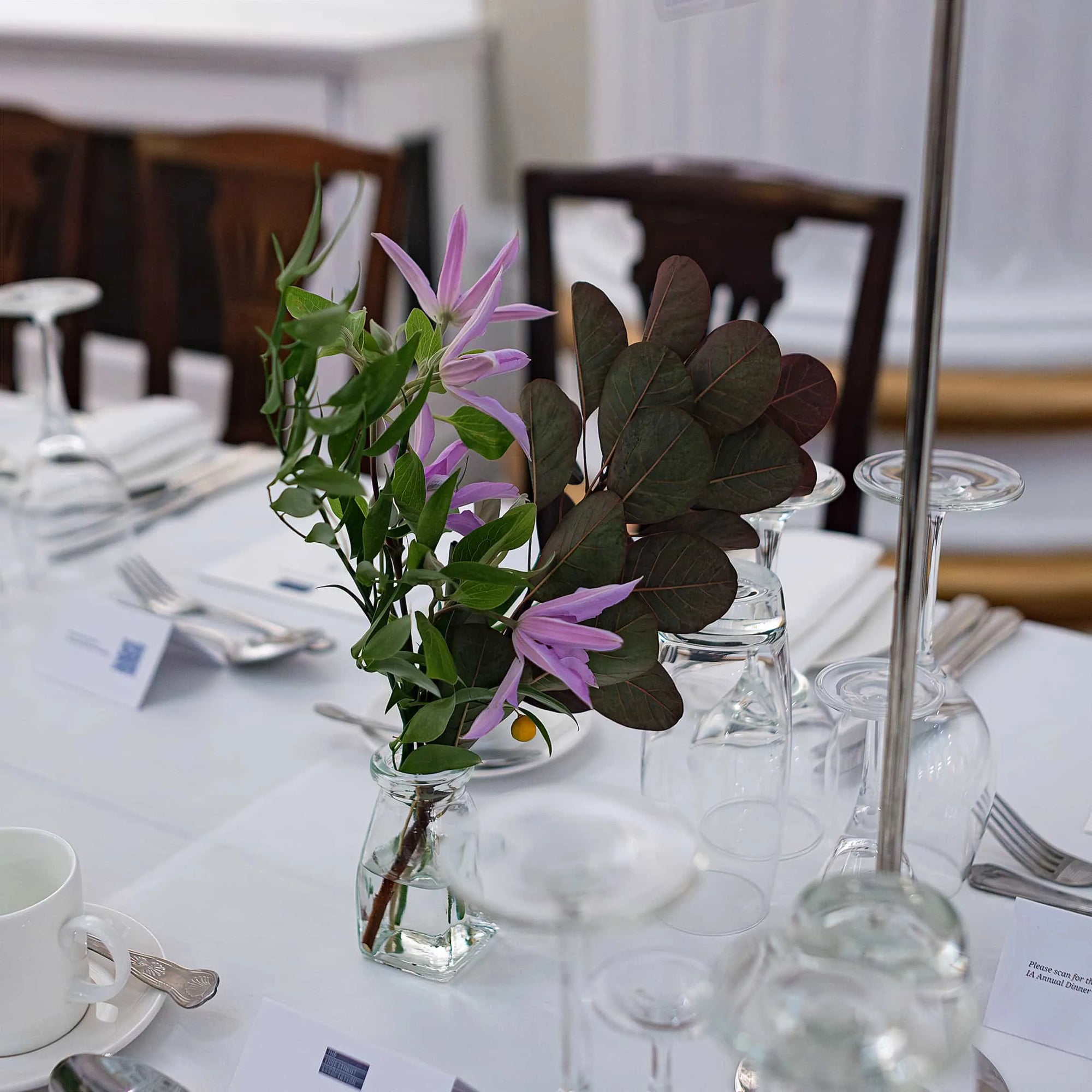 A solitary bloom in a jar gracing an expansive dining table