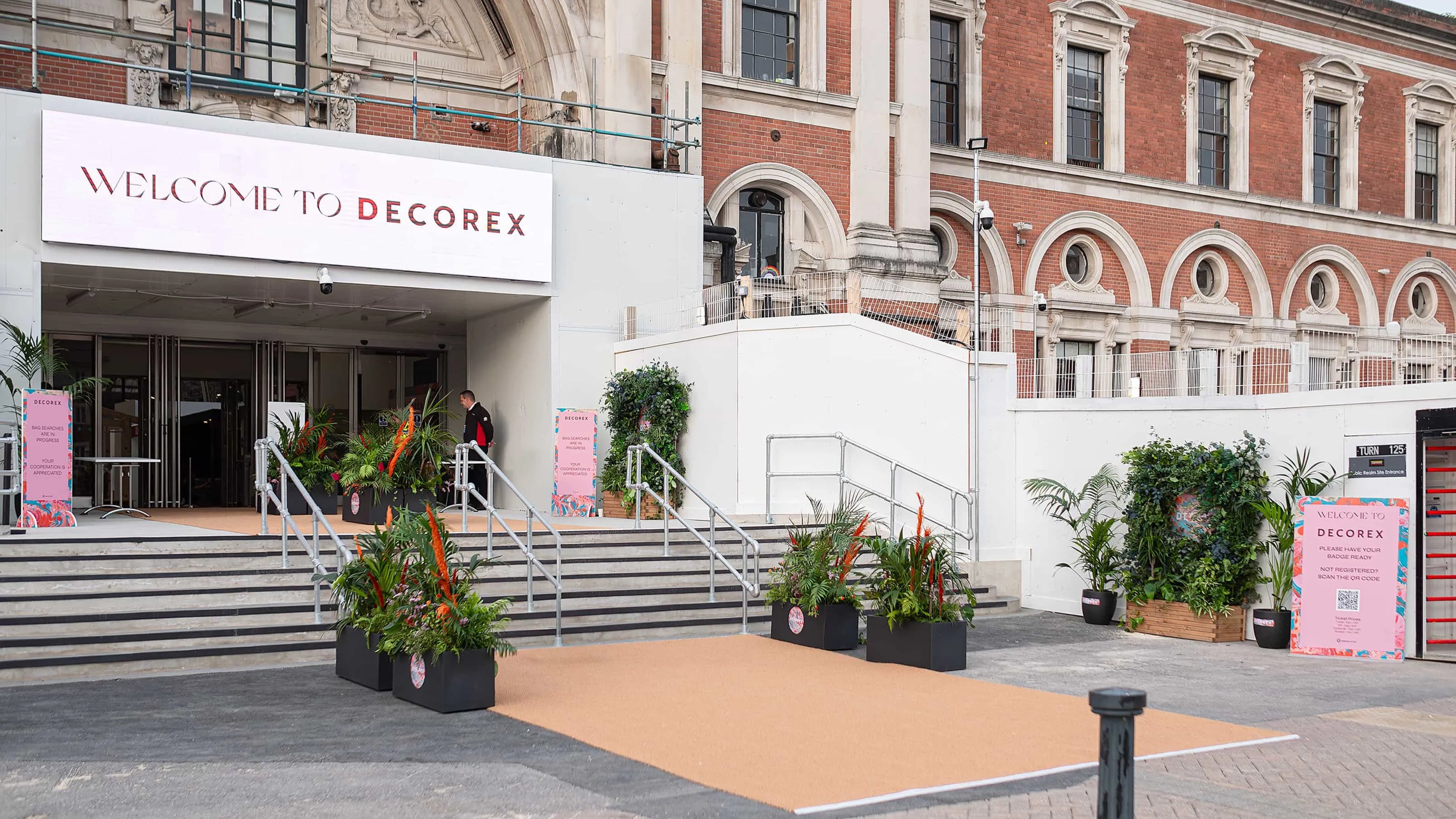 Welcoming entrance to Decorex with stylish planters by Amaranté London, blending lush tropical plants with the elegant architecture of the venue, inviting attendees into the world of interior design.