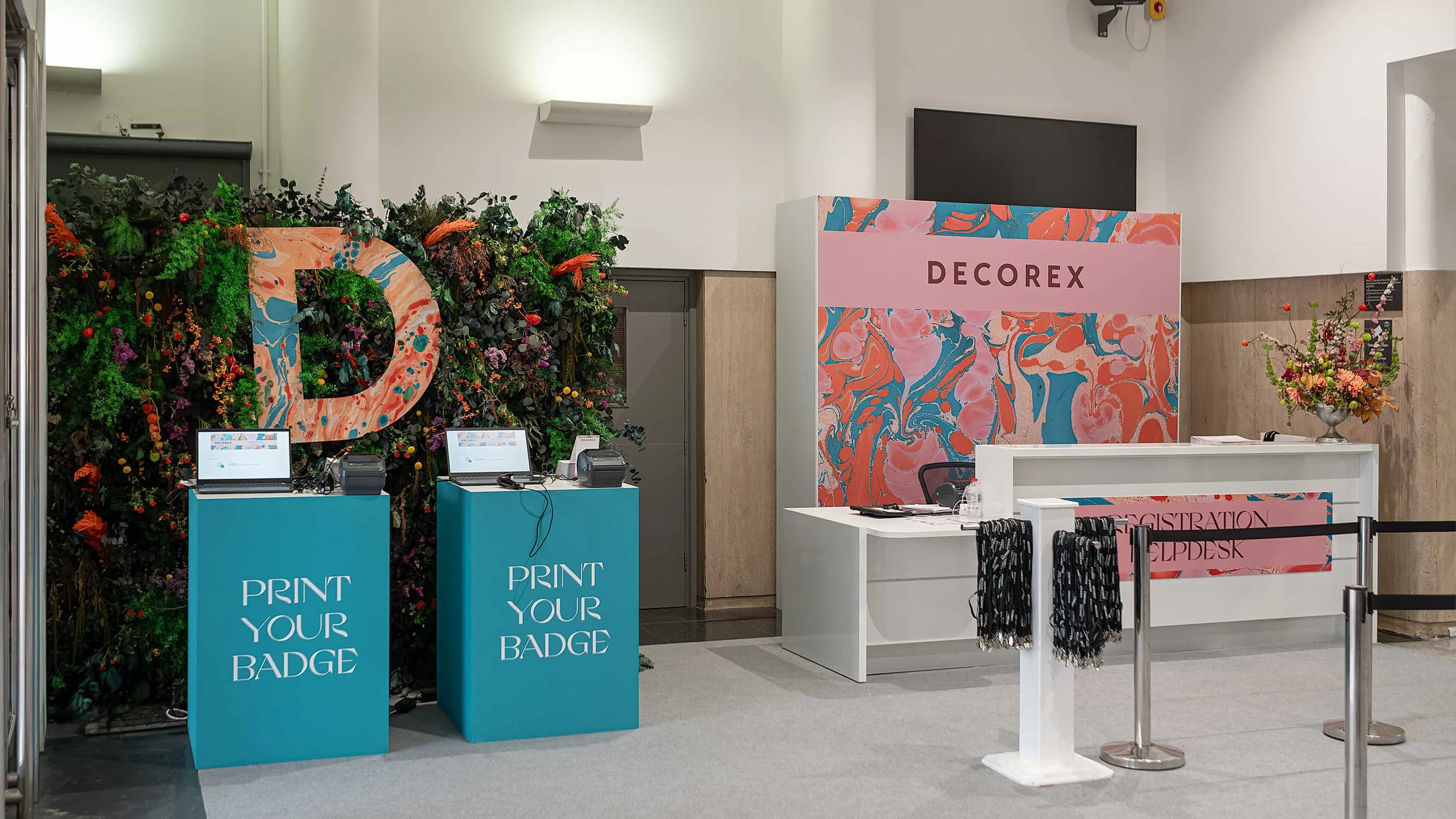 Amaranté London’s floral decor at Decorex, framing the registration area with a lush mix of flowers and plants, highlighting the event’s focus on design and creativity.